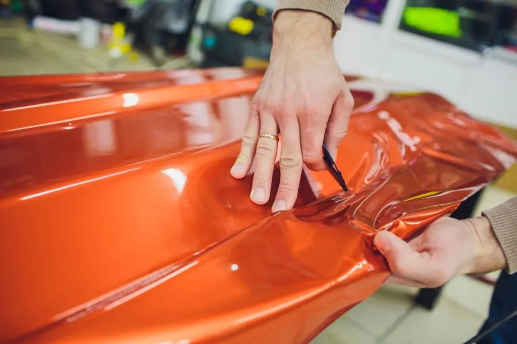 Color change vinyl being applied to a car panel