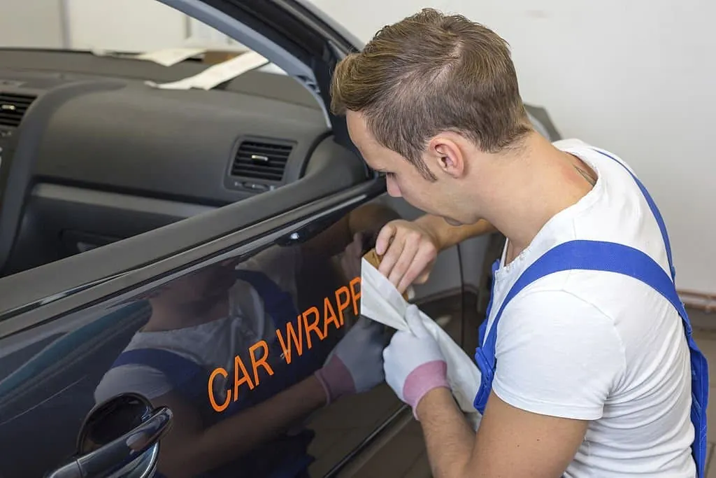 Lettering graphics being applied to a vehicle door