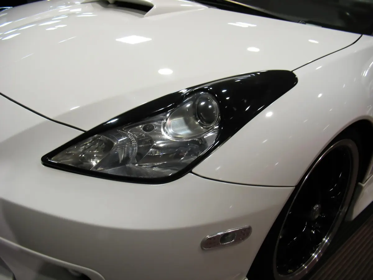 Front bumper and headlight of a white car, the area paint protection film covers first